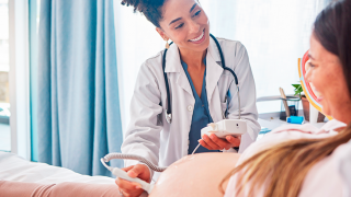 Médica realiza um exame de ultrassom em paciente grávida
